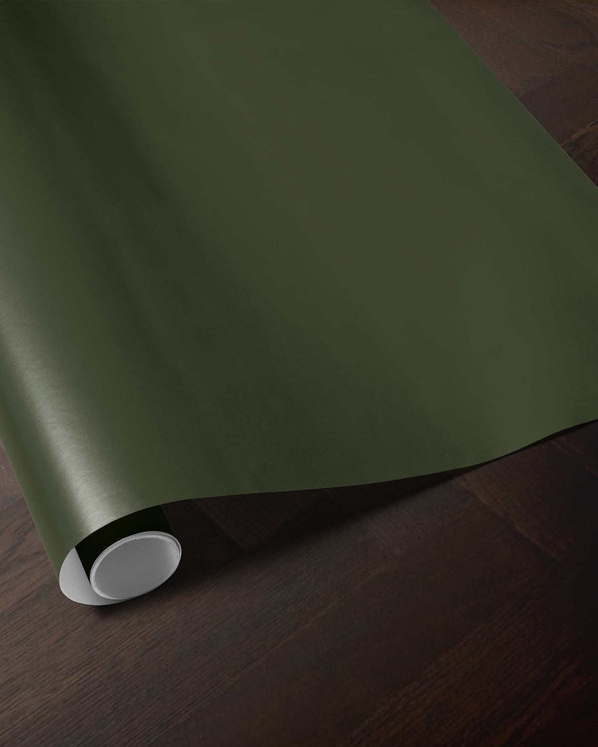 Dark green wrapping paper roll showing the rich solid color and smooth paper finish
